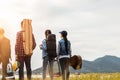 A group of friends traveling camping near the river. People holding tent and chair