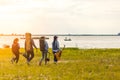 A group of friends traveling camping near the river. People holding tent and chair