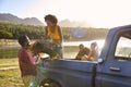 Group Of Friends Unloading Backpack From Pick Up Truck On Road Trip By Lake In Countryside Royalty Free Stock Photo