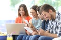 Group of friends using multiple devices at home Royalty Free Stock Photo