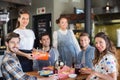Group of friends with waitress in restaurant Royalty Free Stock Photo