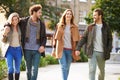 Group Of Friends Walking Through City Park Together