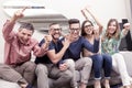 Group of friends watching a football match on tv on the couch Royalty Free Stock Photo