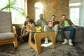 Group of friends watching football or soccer game on TV at home Royalty Free Stock Photo