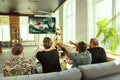 Group of friends watching football or soccer game on TV at home Royalty Free Stock Photo