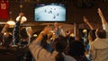 Group of Friends Watching a Live Ice Hockey Match on TV in a Sports Bar. Excited Fans Cheering and Royalty Free Stock Photo