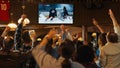 Group of Friends Watching a Live Ice Hockey Match on TV in a Sports Bar. Excited Fans Cheering and Royalty Free Stock Photo