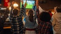 Group of Friends Watching a Live Soccer Match on TV in a Sports Bar. Excited Fans Cheering and Royalty Free Stock Photo