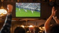 Group of Friends Watching a Live Soccer Match on TV in a Sports Bar. Excited Fans Cheering and Royalty Free Stock Photo