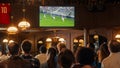 Group of Friends Watching a Live Soccer Match on TV in a Sports Bar. Excited Fans Cheering and Royalty Free Stock Photo