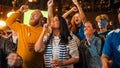 Group of Friends Watching a Live Soccer Match on TV in a Sports Bar. Excited Fans with Painted Faces Royalty Free Stock Photo