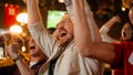 Group of Friends Watching a Live Soccer Match on TV in a Sports Bar. Happy Fans Cheering and Royalty Free Stock Photo