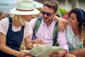 Group of friends are watching the map while while planning a day during a holiday on the seaside. Vacation, friendship, seaside