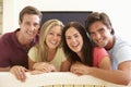 Group Of Friends Watching Widescreen TV At Home Royalty Free Stock Photo