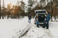 Group friends winter wear snowy winter forest talk drinking coffee car Royalty Free Stock Photo