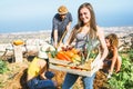 Group of friends working together in a farm house - Happy young woman holding fruit crate with fresh vegetables in the garden Royalty Free Stock Photo