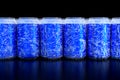 Group of frozen blue aluminum energy drink cans in a row front view