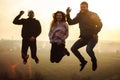 Millennials jump friends in the outdoors at evening spring sunset