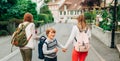 Group of 3 funny kids with backpacks, 2 schoolgirls and one preschooler