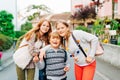 Group of 3 funny kids with backpacks, 2 schoolgirls and one preschooler