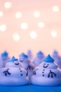 A group of funny meringue snowmen under a festive garland.