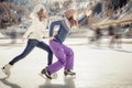 Group funny teenagers ice skating outdoor at ice rink