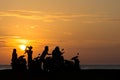 Group Gang of Teenagers Young Adults watch a beach side sun set Royalty Free Stock Photo