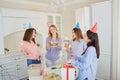 A group of girlfriends with a cake with candles celebrate a birt