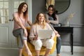 A group of girlfriends communicate with a friend via a video conference on a laptop. Friendship