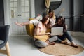 a group of girlfriends communicate with a friend via a video conference on a laptop. Friendship