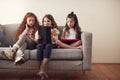 Group Of Girls With Friends Sitting On Sofa At Home Playing On Digital Tablet And Mobile Phones Royalty Free Stock Photo