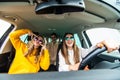 Group of girls having fun in the car, singing songs and dancing in car during road trip Royalty Free Stock Photo