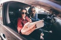 Group of girls having fun with the car. Taking selfie while driving in trip Royalty Free Stock Photo