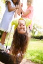 Group Of Girls Having Fun With Friends Playing On Tire Swing In Garden Royalty Free Stock Photo