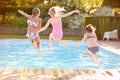 Group Of Girls Jumping Into Outdoor Swimming Pool Royalty Free Stock Photo