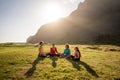 A group of girls meditate at sunset