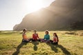 A group of girls meditate at sunset