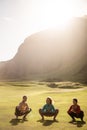 A group of girls meditate at sunset