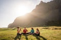 A group of girls meditate at sunset