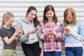 Group Of Young Girls Outdoors Looking At Messages On Mobile Phones Royalty Free Stock Photo