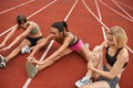 Group of girls stretching on stadium treadmill