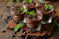 a group of glasses of chocolate mousse with mint leaves