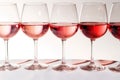 A group of glasses with pink, rose and red wine stand in a line, in a row on a white and pink table. The concept of showing Royalty Free Stock Photo