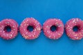 Group of glazed pink donuts on a blue background