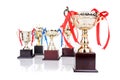 Group of gold trophies with decorative ribbons, focusing on one Royalty Free Stock Photo