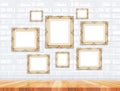 Group of golden Victorian style vintage frames on white tile wall and wood floor,Mock up for adding your photo on picture frames Royalty Free Stock Photo