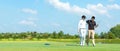 Group golf playing. Professional Golfer asian man walking and hug for friendship after finish put golf ball on green Royalty Free Stock Photo