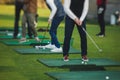 Group of golfers practicing and training golf swing on driving range practice, men playing on golf course, golf ball at golfing Royalty Free Stock Photo