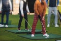 Group of golfers practicing and training golf swing on driving range practice, men playing on golf course, golf ball at golfing Royalty Free Stock Photo