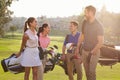 Group Of Golfers Walking Along Fairway Carrying Golf Bags Royalty Free Stock Photo